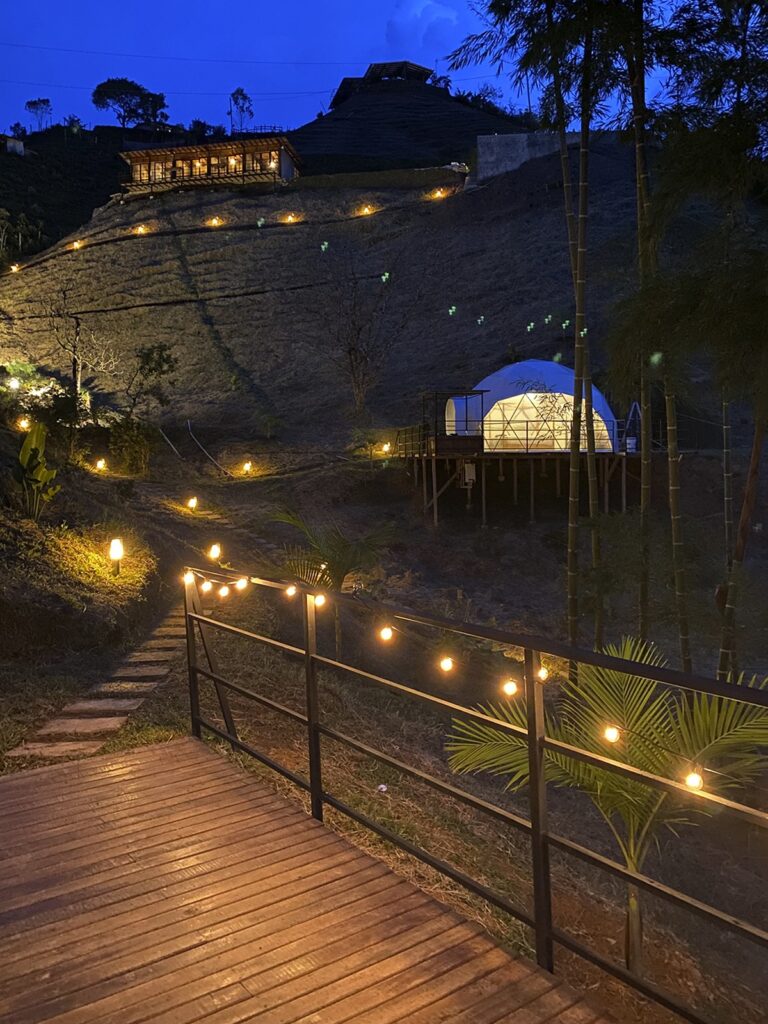 Elysium Glamping iluminado al anochecer