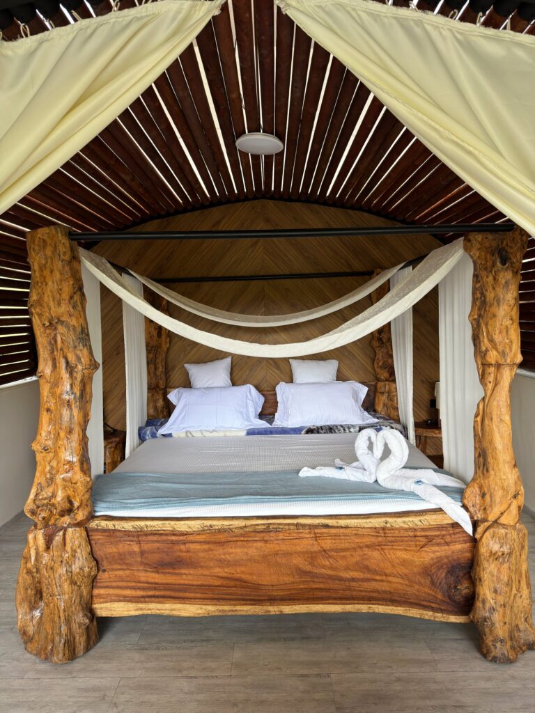 Cama king size de madera rústica en la suite Venus